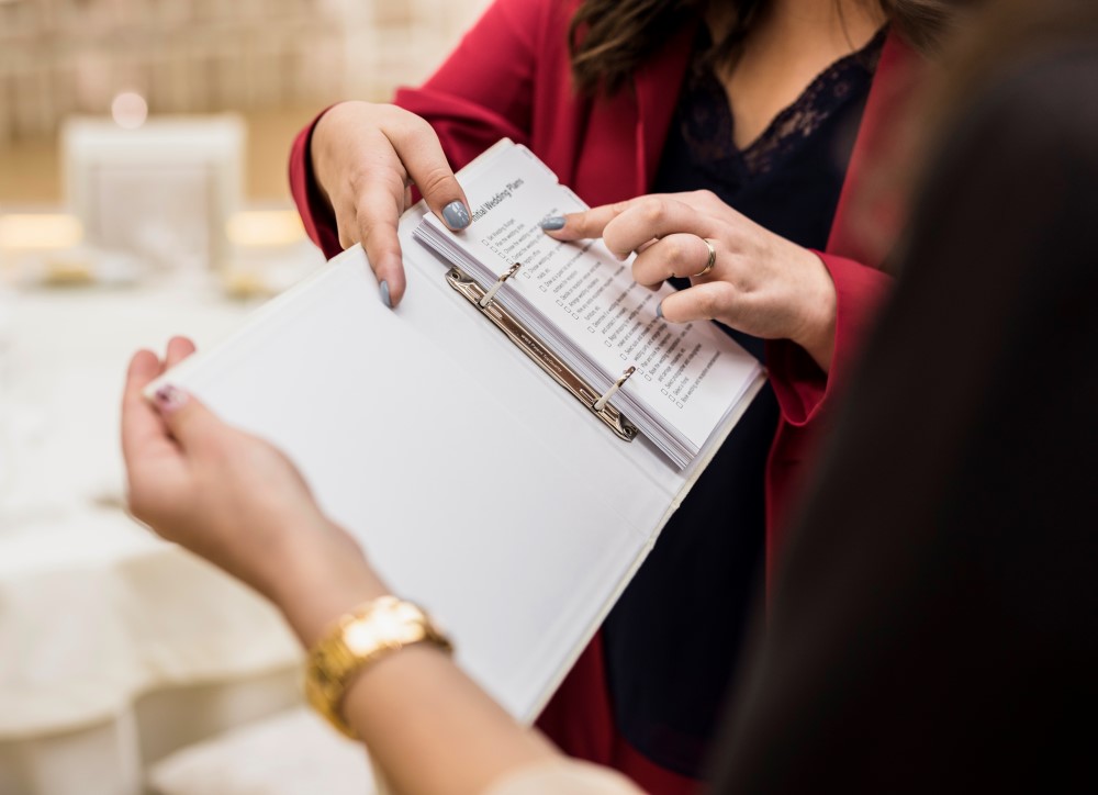 Mujer apuntando en una agenda las cosas que tienen que hacer para que el evento esté bien coordinado